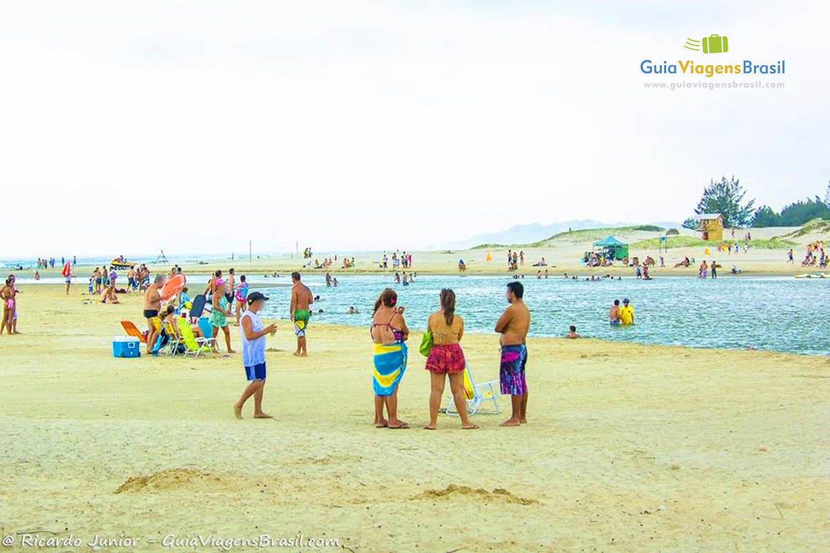 Imagem de pessoas curtindo um belo dia de sol na Praia da Barra de Ibiraquera.
