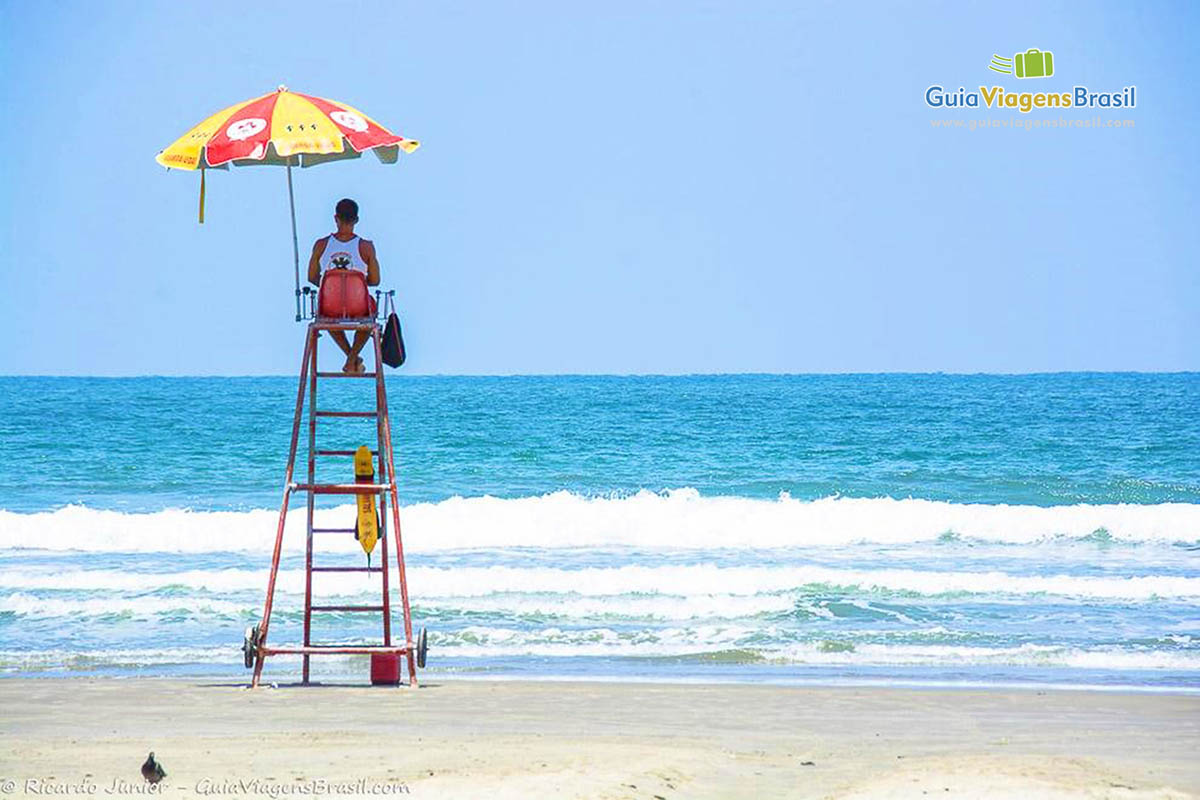 Imagem do lindo mar azul e salva vidas cuidando de turistas na Praia Riviera de São Lourenço.