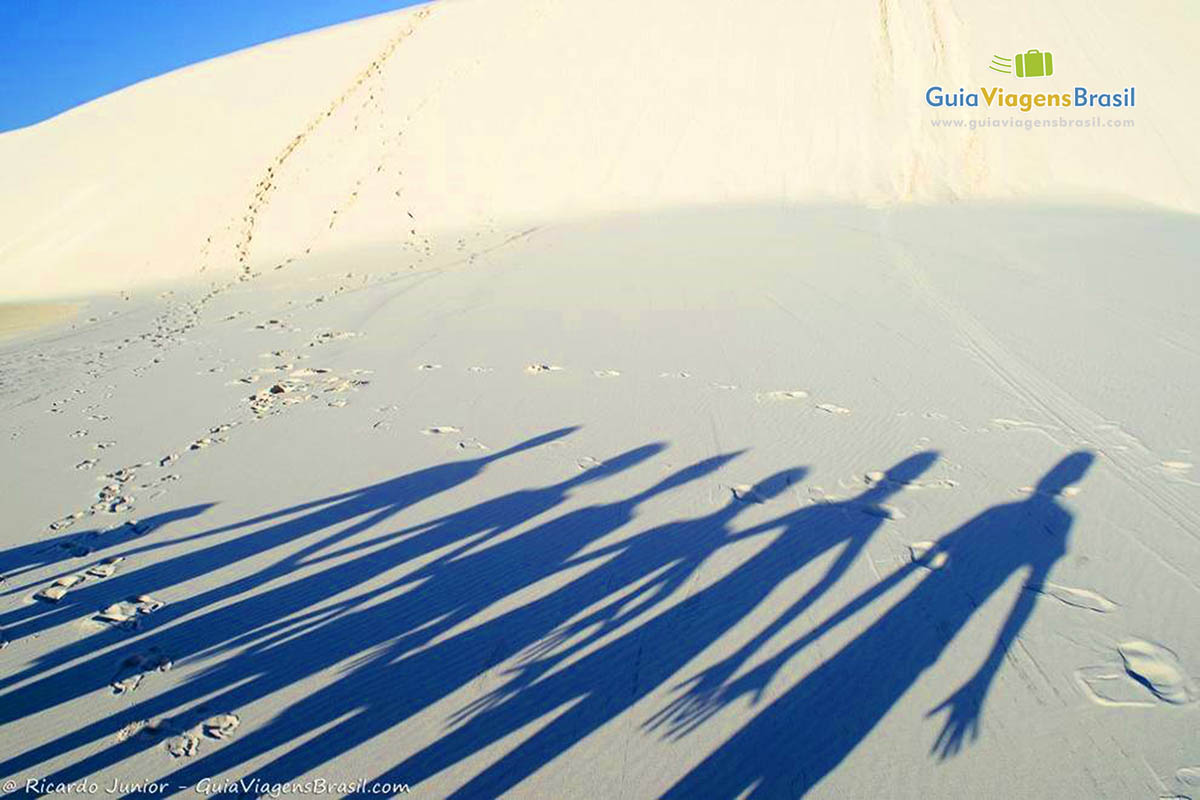 Imagem de sombras das pessoas nas dunas brancas.