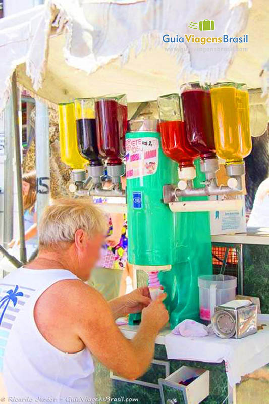 Imagem de vendedor de sorvetes coloridos, tirando da máquina um belo sorvete.