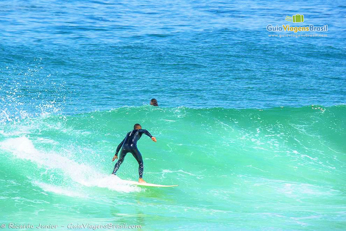 Imagem de surfista deslizando sobre a onda.