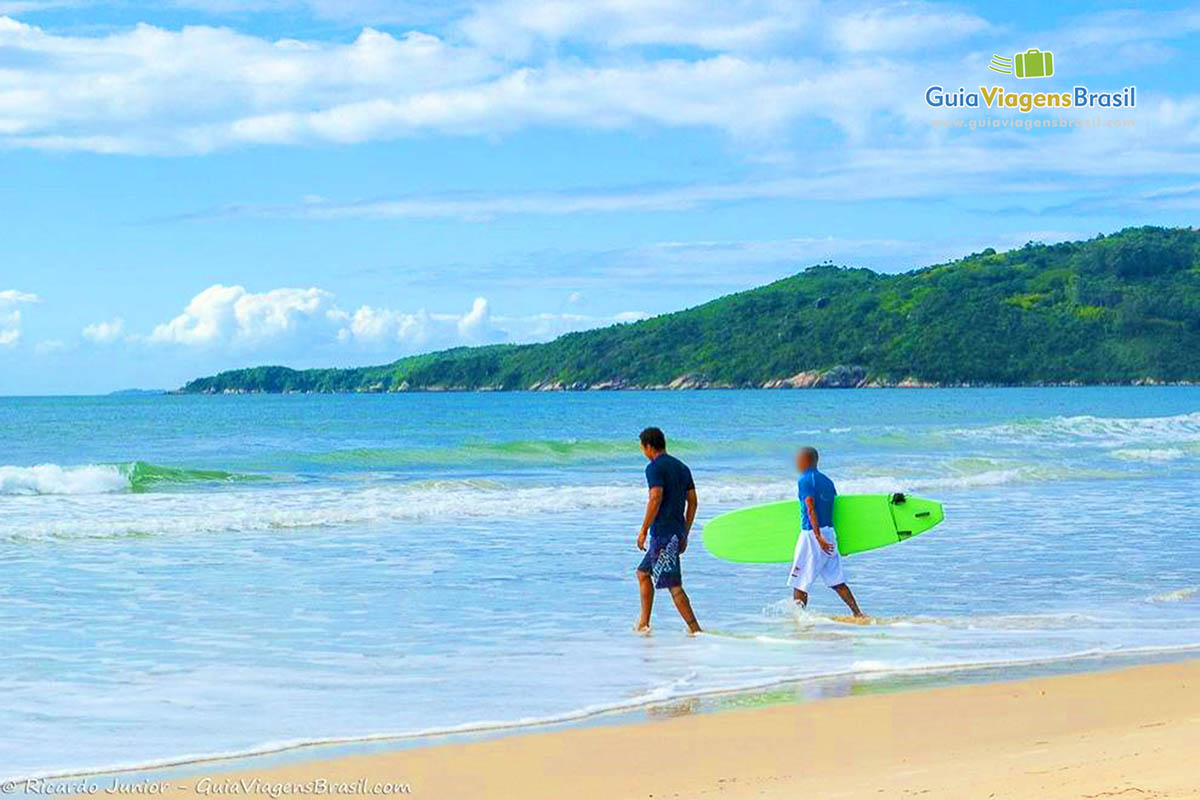 Imagem de surfistas entrando no mar da Praia Mariscal.