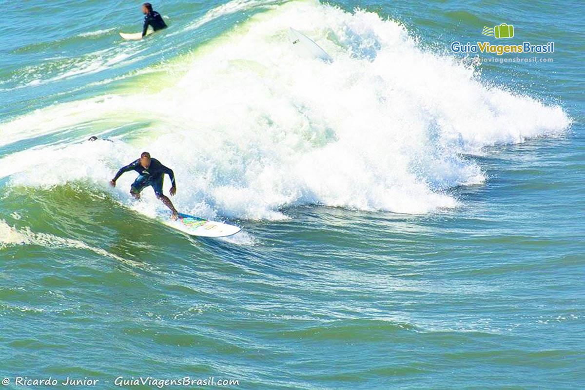 Imagem de surfistas pegando onda na Praia da Barra.