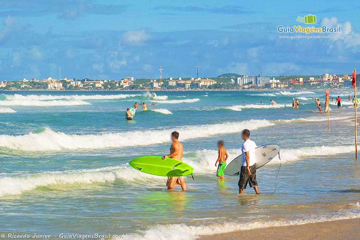 Imagem de dois surfistas entrando no mar.