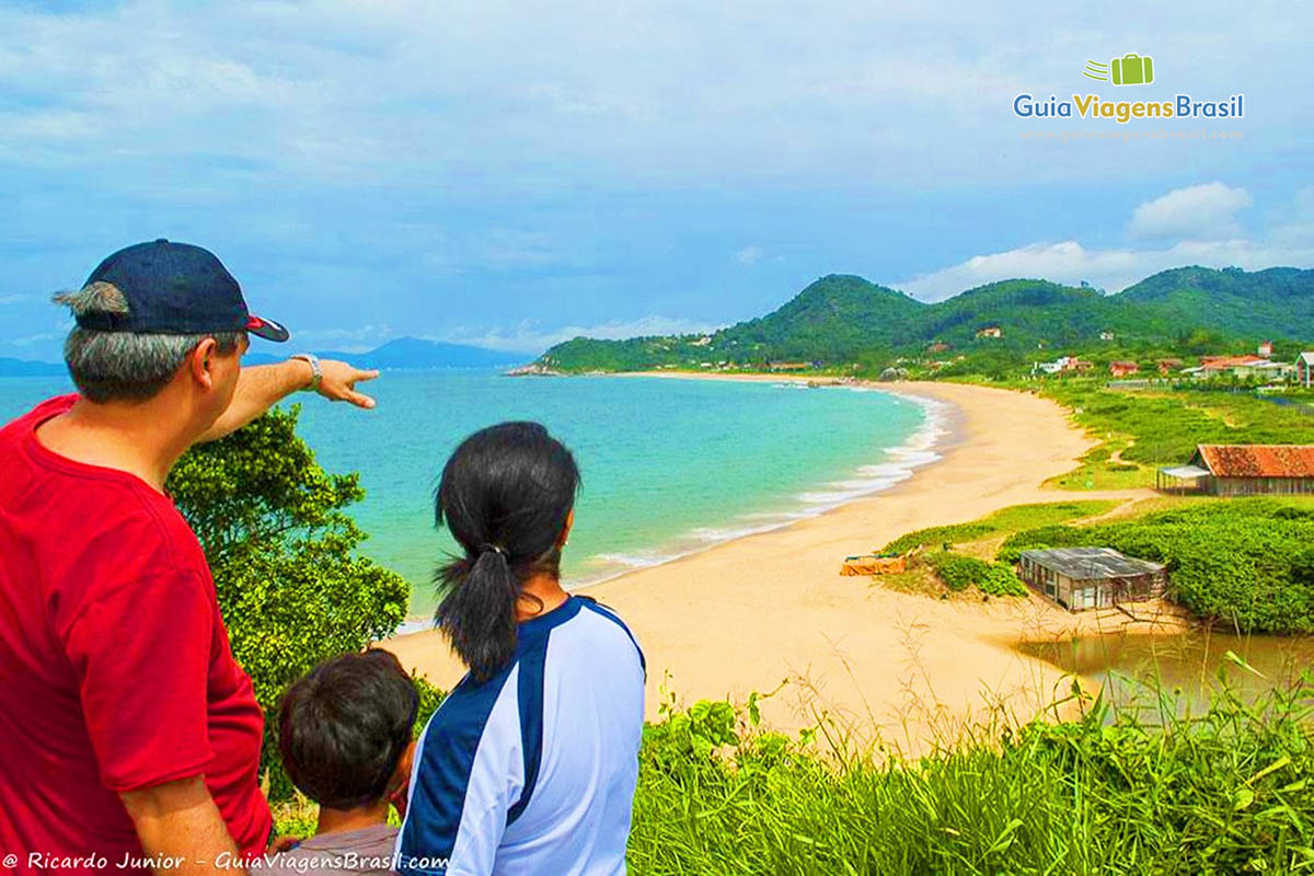 Imagem de turistas admirando  as belezas da Praia do Estaleiro.